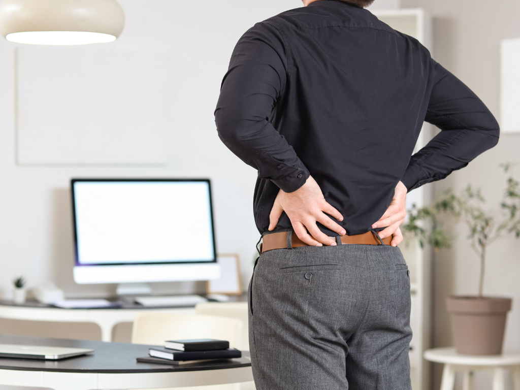 Why does sitting cause lower back pain in the first place?